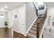 Entryway with carpeted staircase and iron railing, complemented by hardwood floors at 12563 Grape St, Thornton, CO 80241