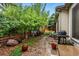 Serene backyard featuring brick flooring, multiple trees with flourishing vegetation, and an outside grill at 3534 Starry Night Loop, Castle Rock, CO 80109