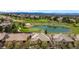 Aerial perspective of houses near a golf course with a pond and mountain views in the distance at 10067 Bluffmont Ct, Lone Tree, CO 80124
