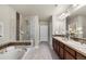 Bathroom featuring a tiled shower, a soaking tub, dual sinks, and modern lighting at 10067 Bluffmont Ct, Lone Tree, CO 80124