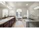 Bathroom featuring a tiled shower, a soaking tub, dual sinks, and modern lighting with a view to the bedroom at 10067 Bluffmont Ct, Lone Tree, CO 80124