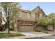 Charming multi-story home boasts stone accents, an attached garage, and well-maintained landscaping at 10067 Bluffmont Ct, Lone Tree, CO 80124