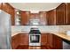 Well-equipped kitchen with stainless steel appliances, tile backsplash, and custom wood cabinetry at 10067 Bluffmont Ct, Lone Tree, CO 80124