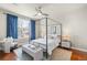 Bedroom with hardwood floors, a four-poster bed, a ceiling fan, and a large window with natural light at 10067 Bluffmont Ct, Lone Tree, CO 80124