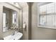 Cozy powder room features a pedestal sink, large mirror, and neutral tones for a clean, modern feel at 10067 Bluffmont Ct, Lone Tree, CO 80124