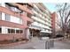 Apartment building featuring a brick facade, well-maintained landscaping, and a welcoming entrance on a sunny day at 1196 N Grant St # 104, Denver, CO 80203