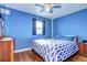 This bedroom features blue walls, hardwood floors, and a ceiling fan for a cool and stylish space at 4070 W Exposition Ave, Denver, CO 80219