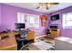 This vibrant purple bedroom offers a dedicated workspace, natural light and personal touches at 4070 W Exposition Ave, Denver, CO 80219