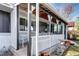 Close up of the covered front porch with a seating area and updated white brick exterior at 4070 W Exposition Ave, Denver, CO 80219