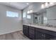 A double vanity bathroom is equipped with wood floors, granite countertops, and recessed lighting at 13531 E 99Th Pl, Commerce City, CO 80022