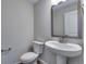 Clean, half-bathroom featuring a modern pedestal sink and toilet at 13531 E 99Th Pl, Commerce City, CO 80022