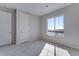 Cozy carpeted bedroom with neutral walls and a large window offering a bright view at 13531 E 99Th Pl, Commerce City, CO 80022
