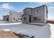 A modern gray home with an entrance to the backyard at 13531 E 99Th Pl, Commerce City, CO 80022