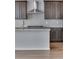 Modern kitchen with gray cabinets, subway tile backsplash, and a stainless steel range hood at 13531 E 99Th Pl, Commerce City, CO 80022