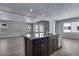 Kitchen island features a sink, stainless steel dishwasher, dark cabinetry, and an open layout at 13531 E 99Th Pl, Commerce City, CO 80022