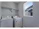 Practical laundry room equipped with washer, dryer, and overhead shelving at 13531 E 99Th Pl, Commerce City, CO 80022