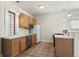 Well-lit kitchen with wooden cabinets, stainless steel appliances, and neutral tile flooring at 914 E Iowa Ave, Denver, CO 80210