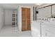 Bright laundry room featuring white appliances and louvered doors at 914 E Iowa Ave, Denver, CO 80210