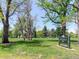Lush green park with mature trees, featuring a sign for James H. Platt Park at 914 E Iowa Ave, Denver, CO 80210