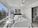 Sun-filled bedroom with a cozy bed, stylish accents, a ceiling fan, and exterior view through large windows at 1007 Chase St, Lakewood, CO 80214
