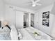 Comfortable bedroom with large windows, a ceiling fan, and a sliding door leading to the ensuite bathroom at 1007 Chase St, Lakewood, CO 80214