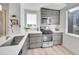 Bright kitchen boasts gray wood cabinets, white countertops, and stainless steel appliances at 1007 Chase St, Lakewood, CO 80214
