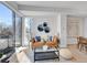 Living room with a sofa, decorative pillows, glass table, and large windows for natural light at 1007 Chase St, Lakewood, CO 80214