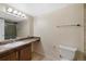 Bathroom featuring a single vanity, large mirror, a toilet, and a shower with glass doors at 4681 S Decatur St # 227, Englewood, CO 80110