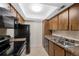 The kitchen features wood cabinets, black appliances, and tile flooring for a functional space at 4681 S Decatur St # 227, Englewood, CO 80110