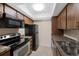 The kitchen features wood cabinets, black appliances, and tile flooring for a functional space at 4681 S Decatur St # 227, Englewood, CO 80110