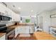 Open-concept kitchen boasting white cabinetry, stainless steel appliances, and seamless flow into the living space at 6142 Gorham St, Frederick, CO 80530