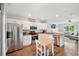 Well-lit kitchen features stainless steel appliances, white cabinetry, and a view into the cozy living room at 6142 Gorham St, Frederick, CO 80530