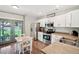 Modern kitchen featuring stainless steel appliances, white cabinets, and a view of the backyard through glass patio doors at 6142 Gorham St, Frederick, CO 80530