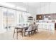 Open-concept dining area connected to the kitchen, featuring a large table and sliding doors to outdoor patio at 6251 N Galena St, Denver, CO 80238