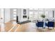 Bright, open-concept living room featuring hardwood floors, fireplace, and ample natural light from large windows at 6251 N Galena St, Denver, CO 80238