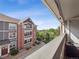 Exterior view of condo with multiple decks, brick facade, and lush landscaping at 14439 E 1St Dr # C11, Aurora, CO 80011