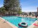 Community pool with lounge chairs, a fence surround, and mature trees at 14439 E 1St Dr # C11, Aurora, CO 80011