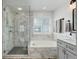 Modern bathroom with tiled shower, tub, and gray vanity at 9954 Heywood St, Highlands Ranch, CO 80130