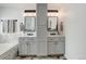 Double vanity bathroom with stylish mirrors, modern fixtures, and gray cabinets at 9954 Heywood St, Highlands Ranch, CO 80130