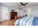 Bright bedroom featuring hardwood floors, ceiling fan, and ensuite bathroom access at 9954 Heywood St, Highlands Ranch, CO 80130