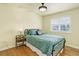 Cozy bedroom with stylish bed, side table, and window with bright natural light, and hardwood-style flooring at 9954 Heywood St, Highlands Ranch, CO 80130