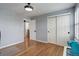 Bright bedroom featuring wood floors, a large double door closet, and hallway access at 9954 Heywood St, Highlands Ranch, CO 80130