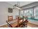 Bright dining room featuring a long wooden table, large window with bench seating, and modern lighting at 9954 Heywood St, Highlands Ranch, CO 80130
