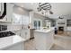 Well-lit kitchen boasting white cabinets, stainless steel appliances, and functional center island at 9954 Heywood St, Highlands Ranch, CO 80130