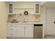 Finished wet bar featuring countertop, tile backsplash, cabinets, and beverage fridge at 9954 Heywood St, Highlands Ranch, CO 80130