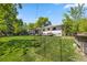 Serene backyard featuring lush green lawn, mature trees, and a fenced garden area, creating a private oasis at 13402 W 24Th Pl, Golden, CO 80401