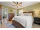 Comfortable bedroom with a ceiling fan, dresser, and soft lighting at 13402 W 24Th Pl, Golden, CO 80401