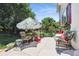 An outdoor patio features decorative umbrellas and floral furniture, surrounded by lush greenery and plants at 17298 E Lake Pl, Aurora, CO 80016