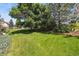 Expansive backyard features a lush green lawn, mature trees, and a wooden fence for privacy at 17298 E Lake Pl, Aurora, CO 80016