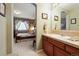 The bathroom boasts a vintage-style vanity leading to a cozy bedroom with a floral design scheme at 17298 E Lake Pl, Aurora, CO 80016
